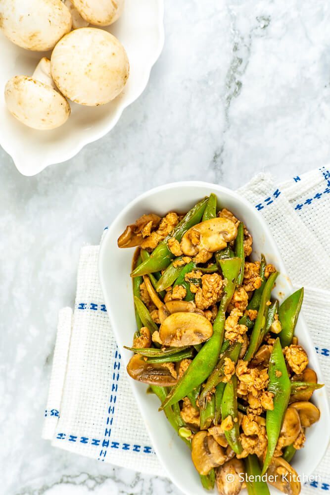 Ground turkey stir fry with green beans and mushrooms on a white plate.