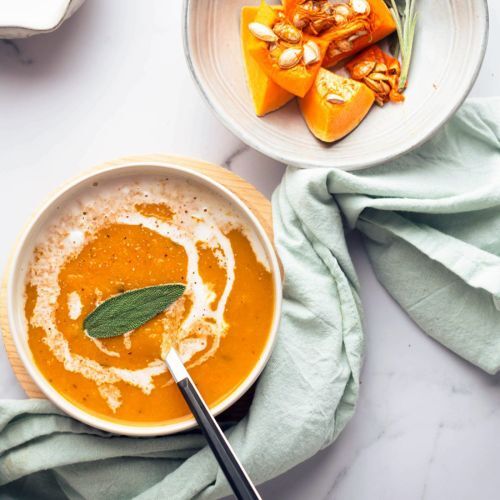 Two Bowls of Butternut Squash Soup Garnished With a Sage Leaf