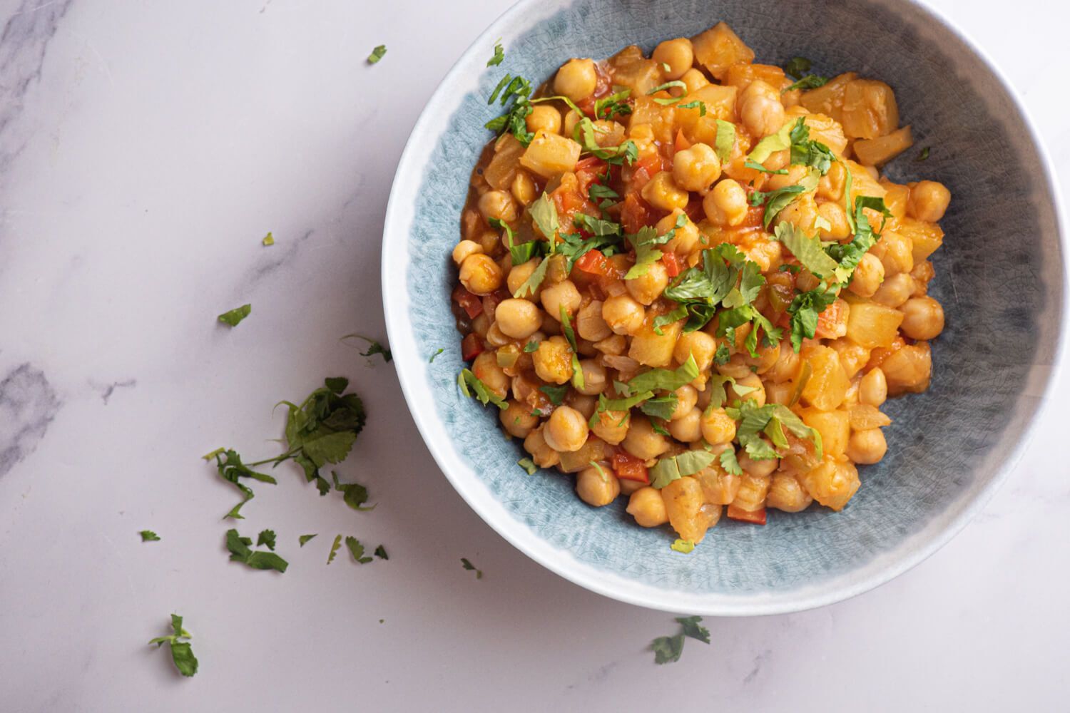 Slow cooker sweet and sour chickpeas with pineapple, red pepper, and cilantro in a bowl.