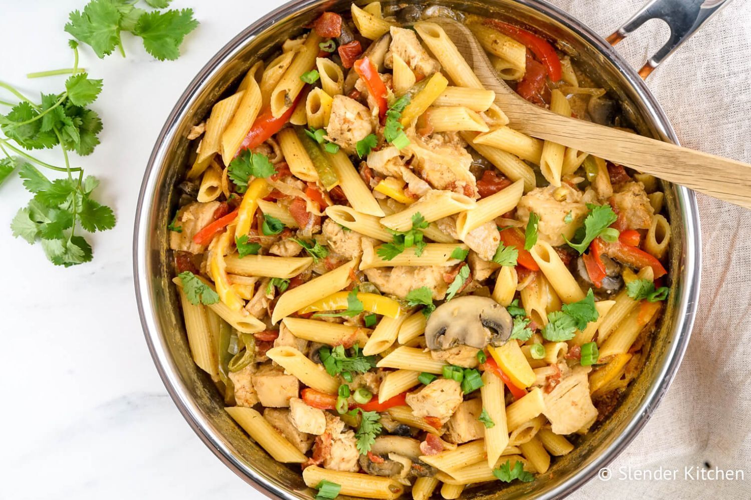Chicken Fajita Pasta in a skillet with mushrooms, peppers, onions, and tomatoes.
