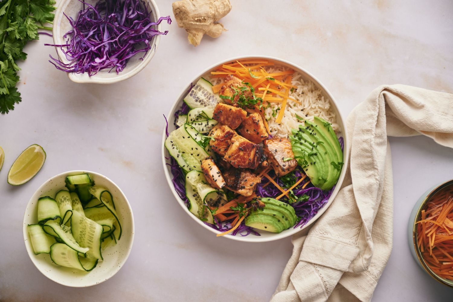 Salmon rice bowls with crispy salmon pieces served with rice, purple cabbage, edamame, carrots, and cucumber.