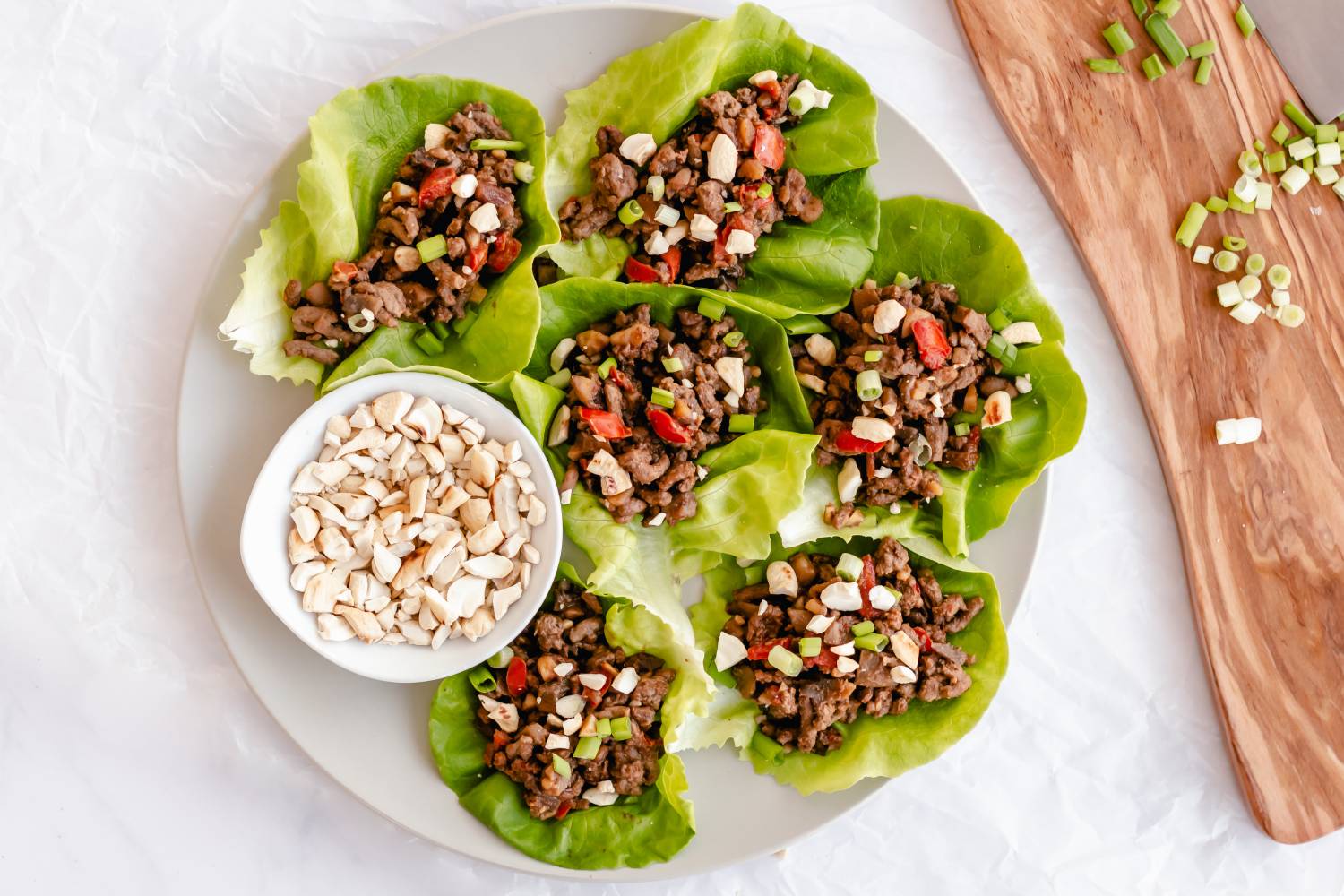 Asian ground beef lettuce wraps with bell peppers, peanuts, and green onions.
