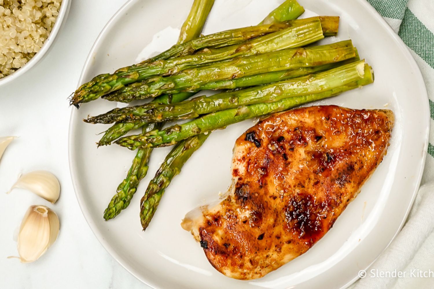 Honey garlic chicken on a plate with asparagus.