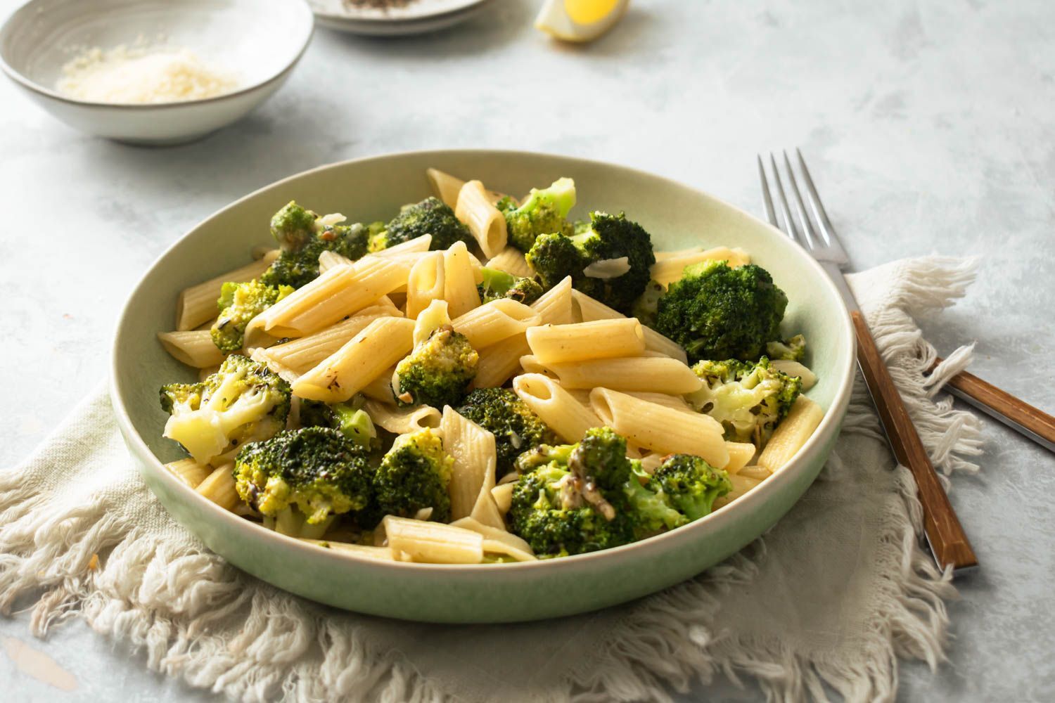 Lemon broccoli pasta in a bowl with fresh lemon juice, garlic, and Parmesan cheese.
