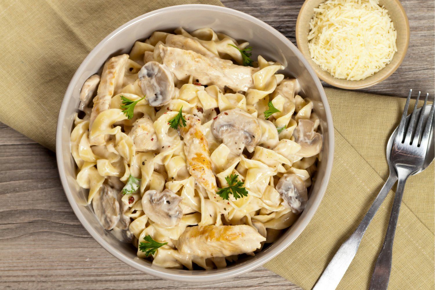 Chicken and Mushroom Pasta in a creamy sauce in a pan with a napkin on the side.