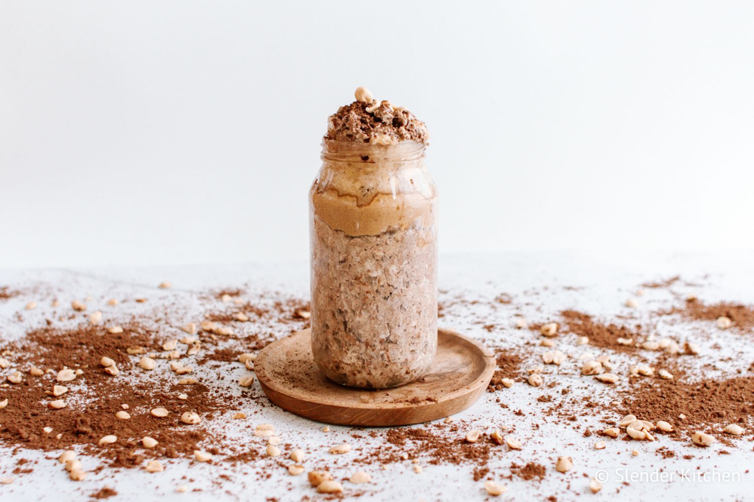 Chocolate peanut butter overnight oats in a glass jar with peanut butter and cocoa powder.