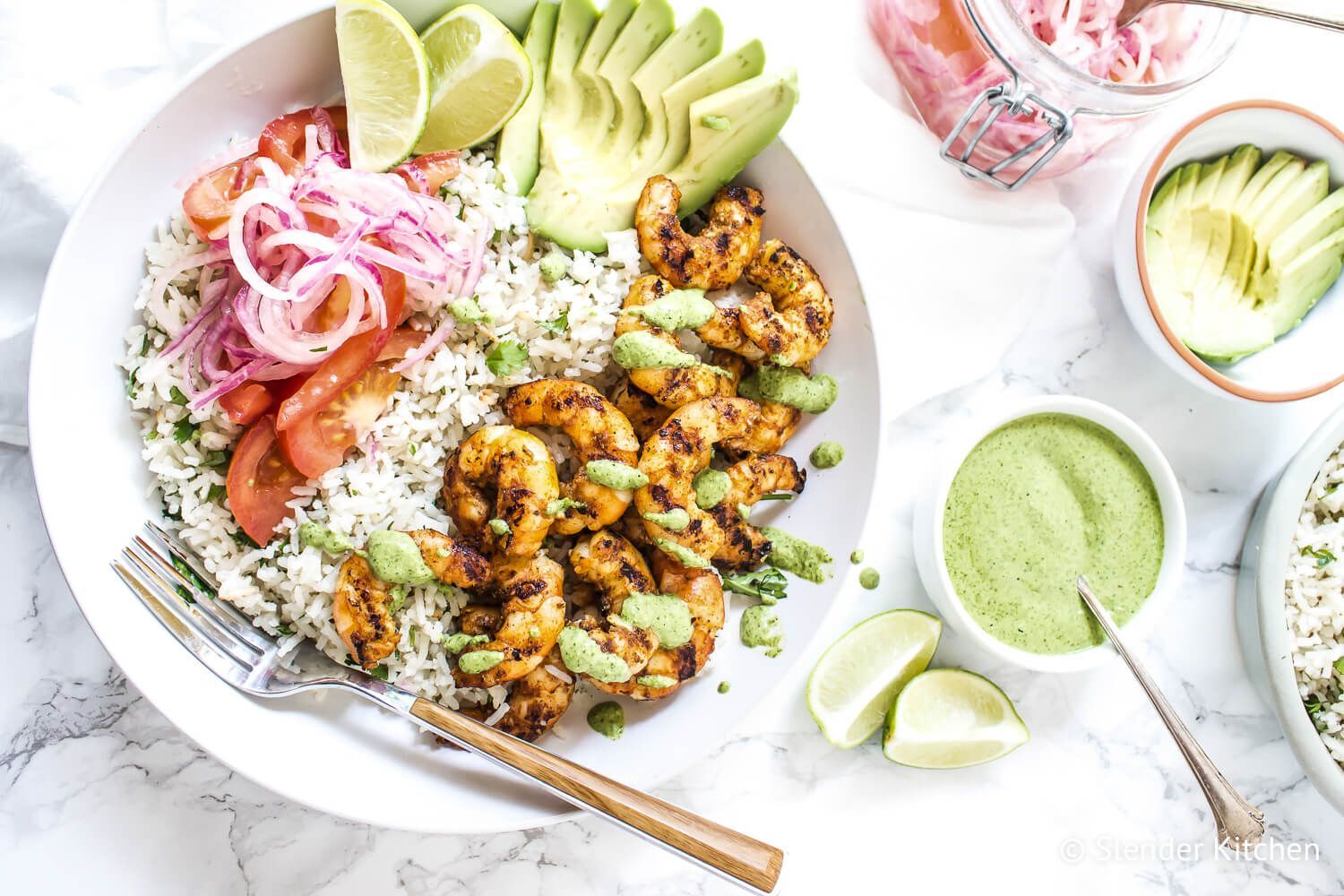 Shrimp rice bowls with grilled shrimp, white rice, cilantro mint sauce, salsa criolla, and sliced avocado.