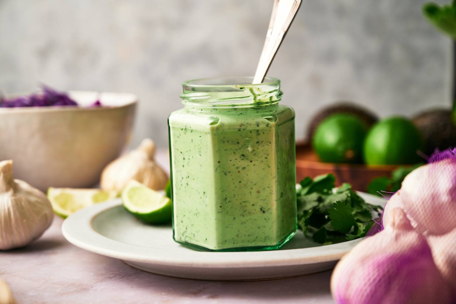 Creamy shrimp taco sauce with cilantro, yogurt, garlic, lime, mayonnaise, and jalapeno in a jar with a spoon.