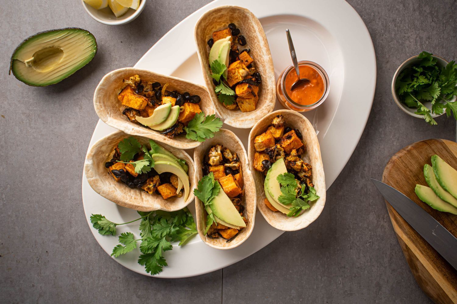 Sweet potato tacos with black beans, cauliflower, avocado, and cilantro served in corn tortillas. 