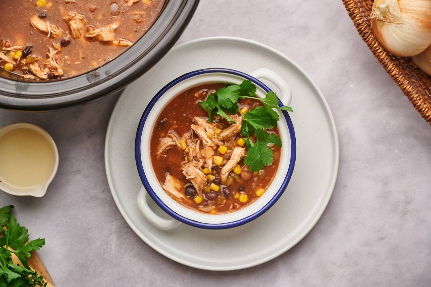 Healthy taco soup with black beans, pinto beans, shredded chicken, cilantro, and cheese.