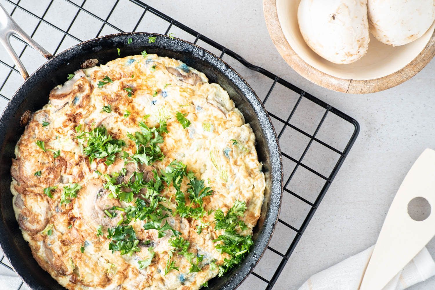 Vegetable and Hashbrown egg casserole in a cast iron skillet with fresh parsley.