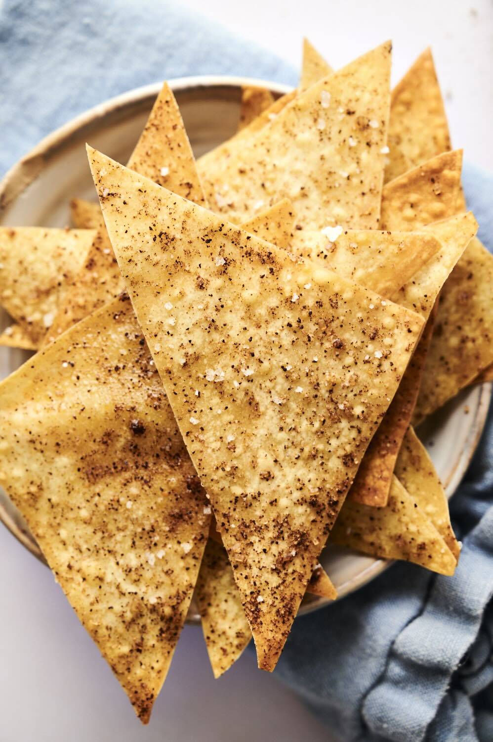 Crispy baked wonton chips sprinkled with cinnamon and sugar on a plate.