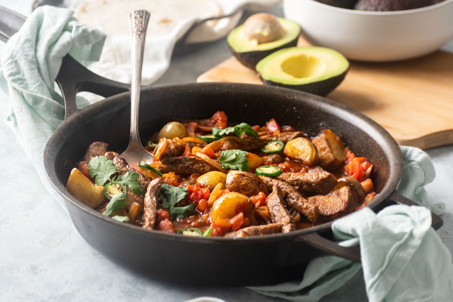 Skillet bistec ranchero with tomatoes, peppers, potatoes, cilantro and sliced ​​jalapenos.