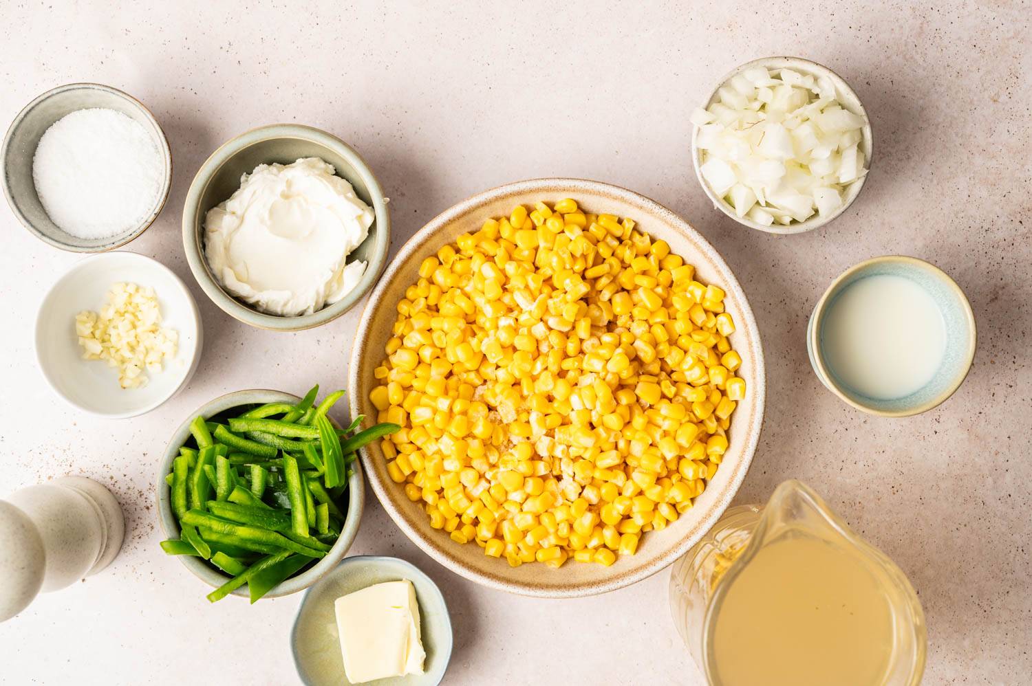 Ingredients for Cream of Corn Soup in a small bowl include corn, peppers, onions, garlic, broth, cream cheese, and milk.