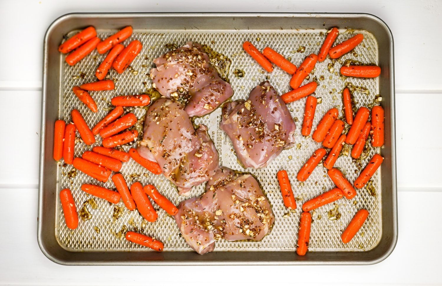 Simple honey mustard chicken thighs are ready for oven and made into a pan.