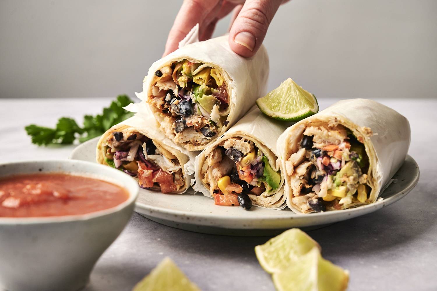Three delicious burritos filled with chicken, black beans and fresh vegetables, served with lemon wedges and dip sauce.