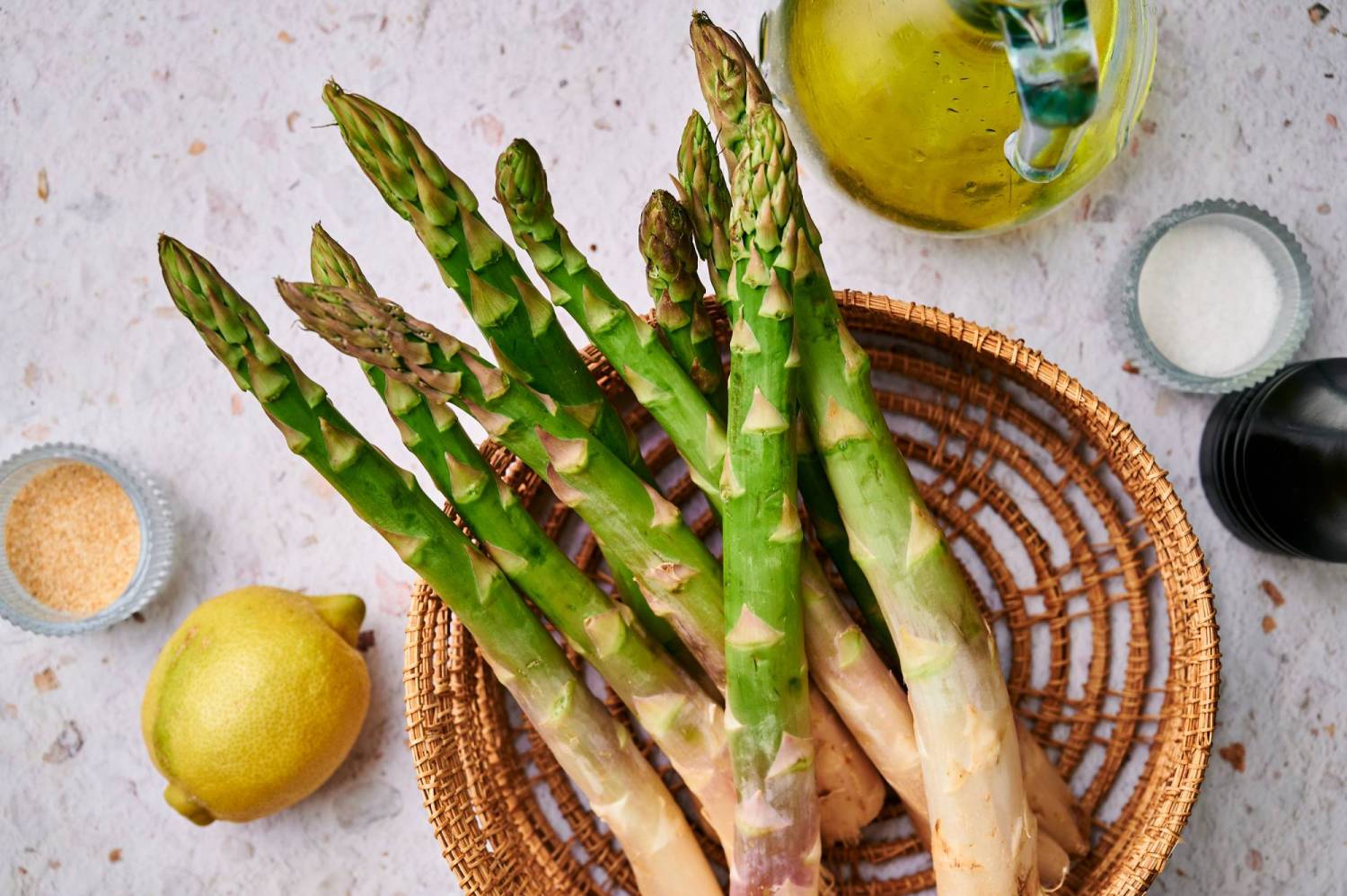 Ingredients for grilled asparagus including asparagus, lemon, olive oil, salt, and pepper.