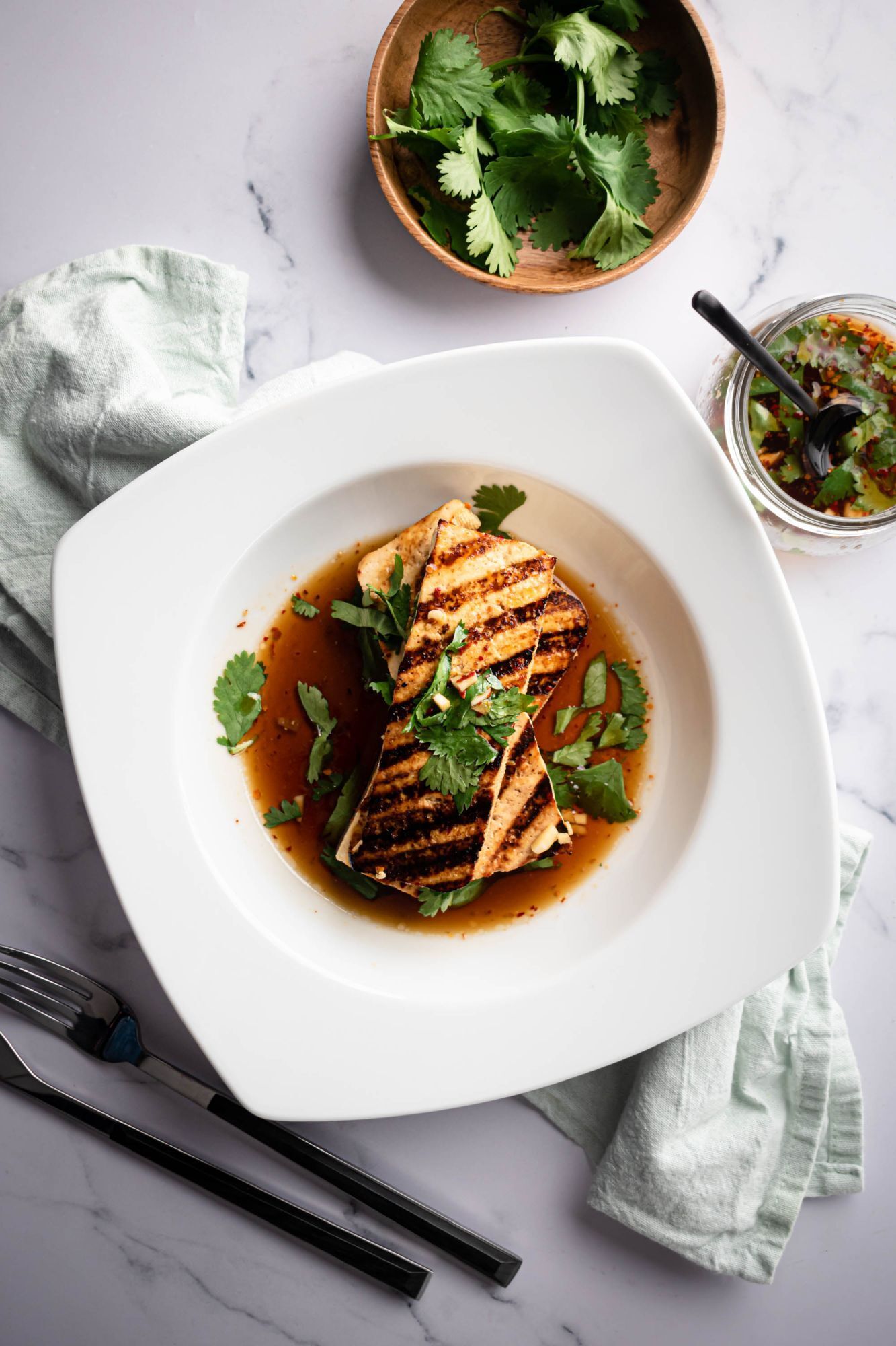 Crispy roasted tofu with a dark grilled flavor, sprinkled with cilantro sauce.