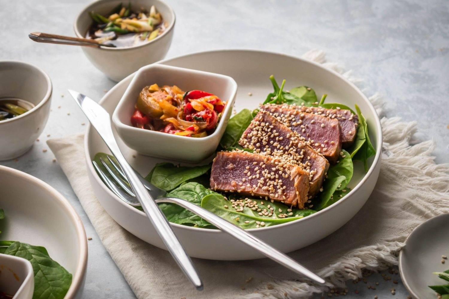 The roasted Ahi Tuna is cooked with rare and sliced ​​it thinly and cut into greens and a pepper on two plates.