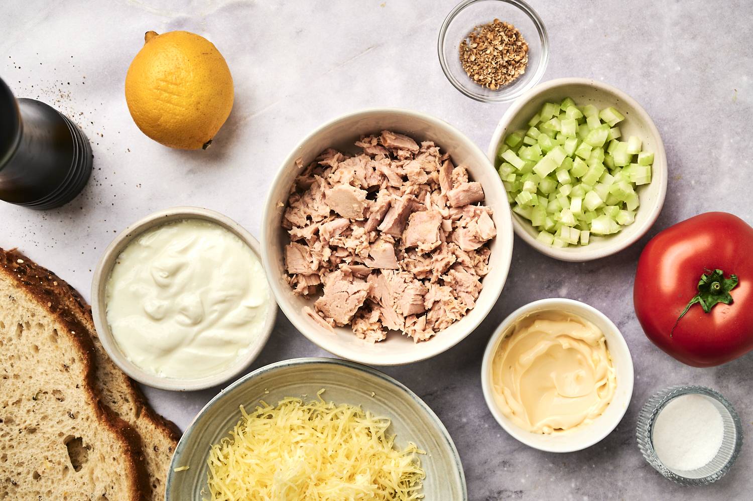 Ingredients for Tuna Salad: Canned tuna, celery, mayonnaise, yogurt, cheese, lemon, tomato, bread and seasoning.