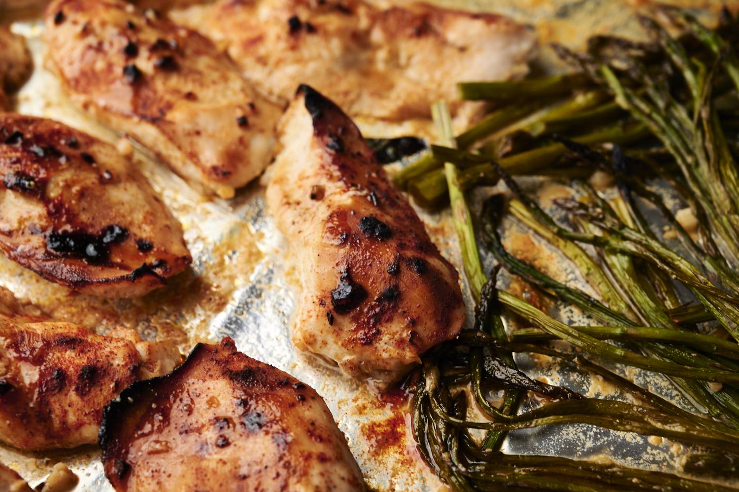 Close-up of honey garlic chicken and asparagus on a plate.