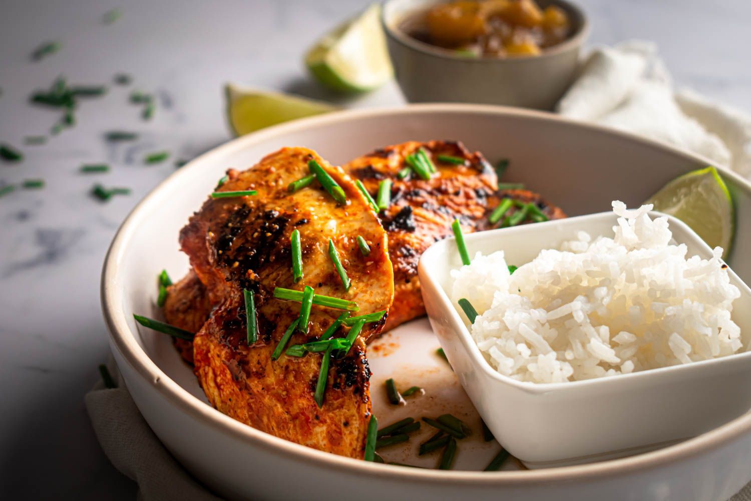 Cook the chicken breast marinated with chili powder, lime juice and garlic and cook until the rice is brown.