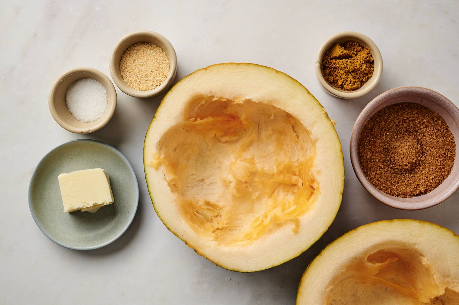 Ingredients for roasted acorn squash including sliced acorn squash, butter, spices, and brown sugar.