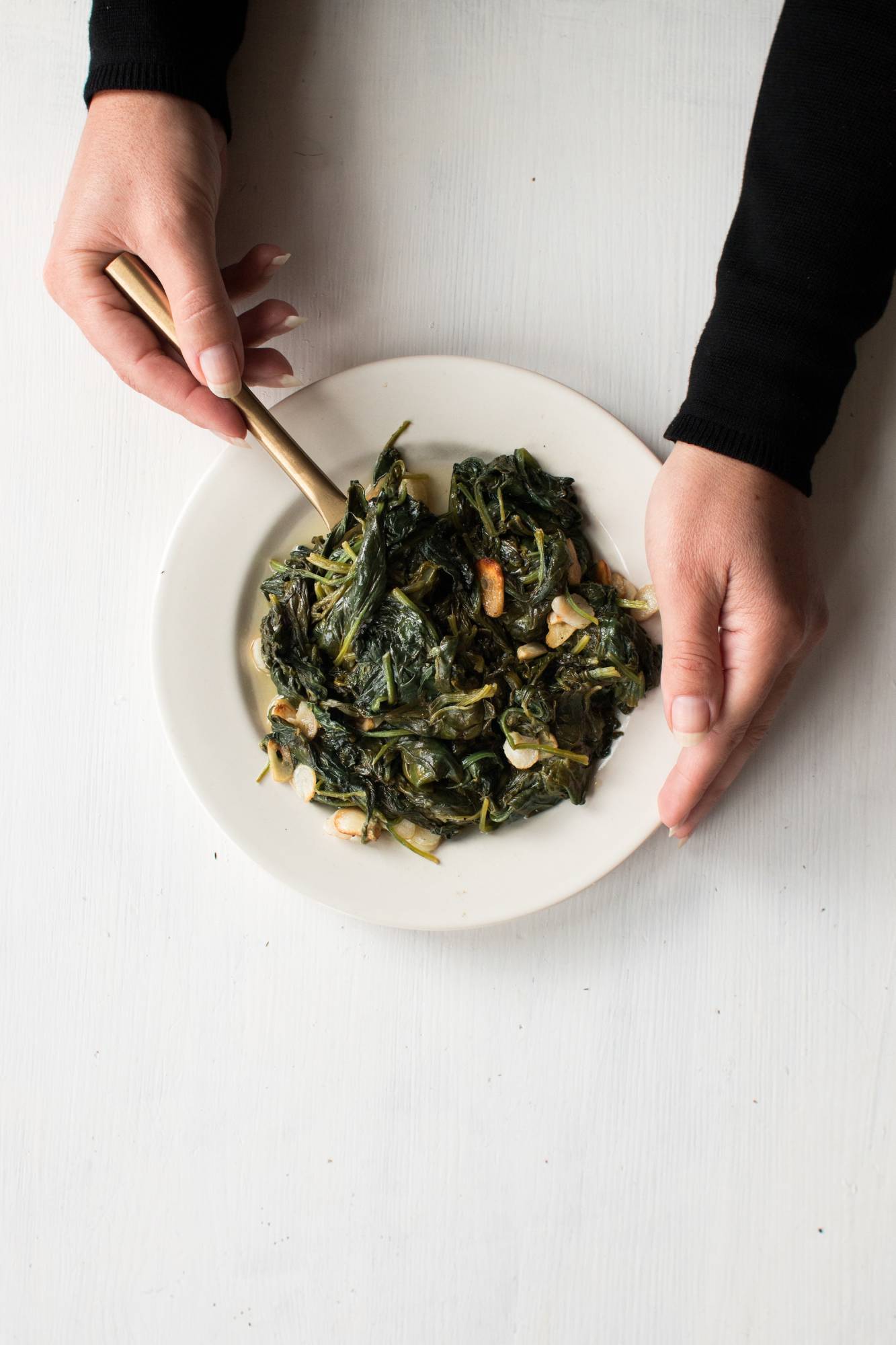 Stir the frying pan with both hands with stir-fry spinach and garlic slices. 