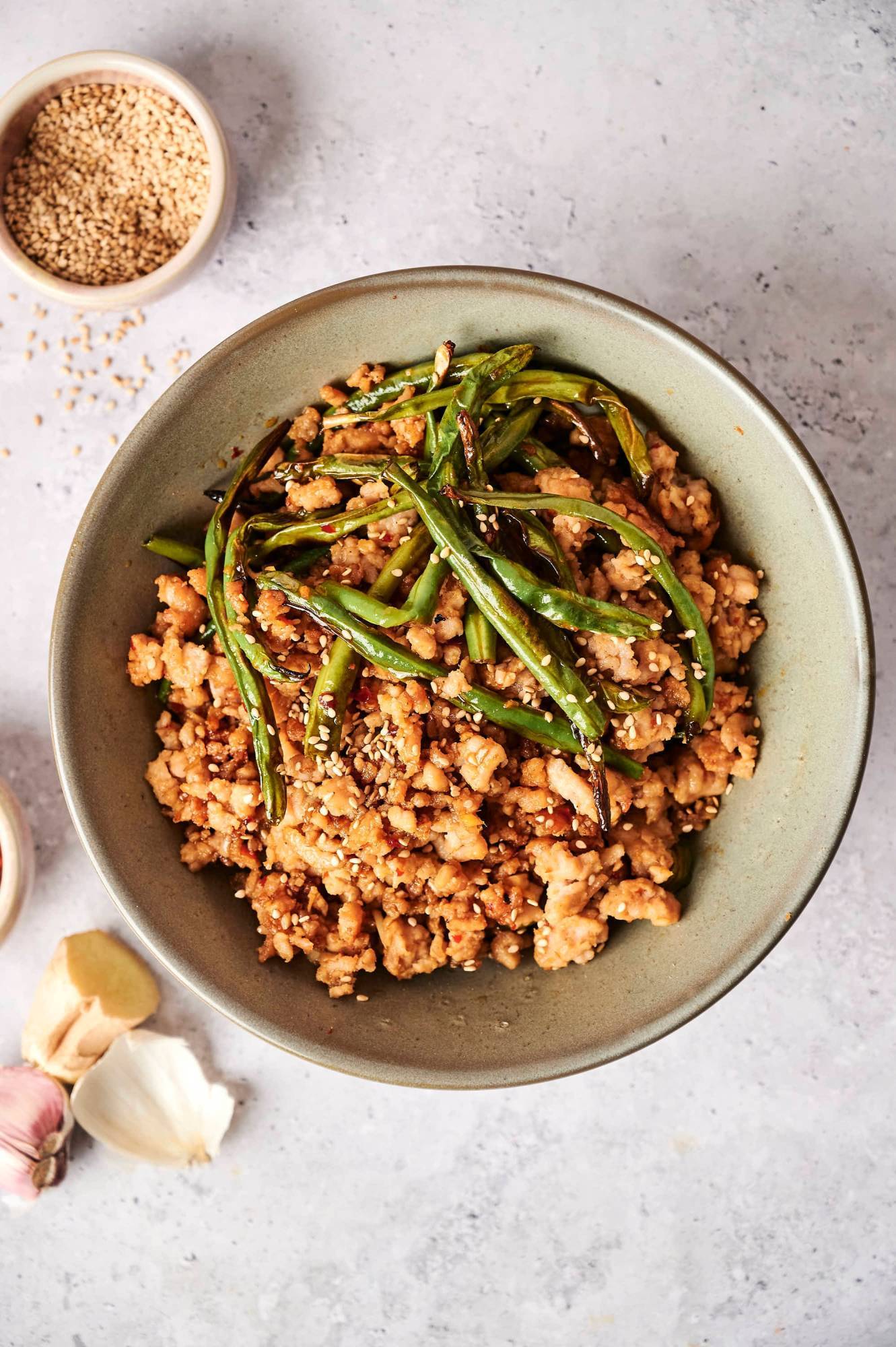 Ground turkey green bean stir fry with sesame seeds served in a bowl.