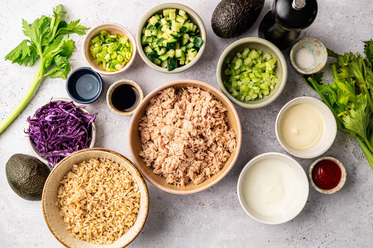 Shredded tuna, shredded cucumber, celery, green onions, purple cabbage, avocado, rice, soy sauce, sauce and other ingredients are neatly placed, ready for the meal. The base is fresh and energizing.