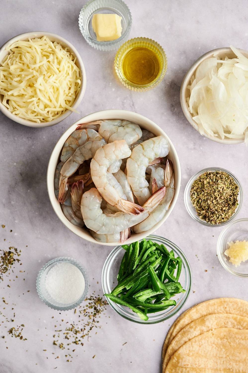 Toppings for the Taco Governor include raw shrimp, shredded cheese, poblano peppers, onions, garlic, oregano, cilantro and lime wedges.