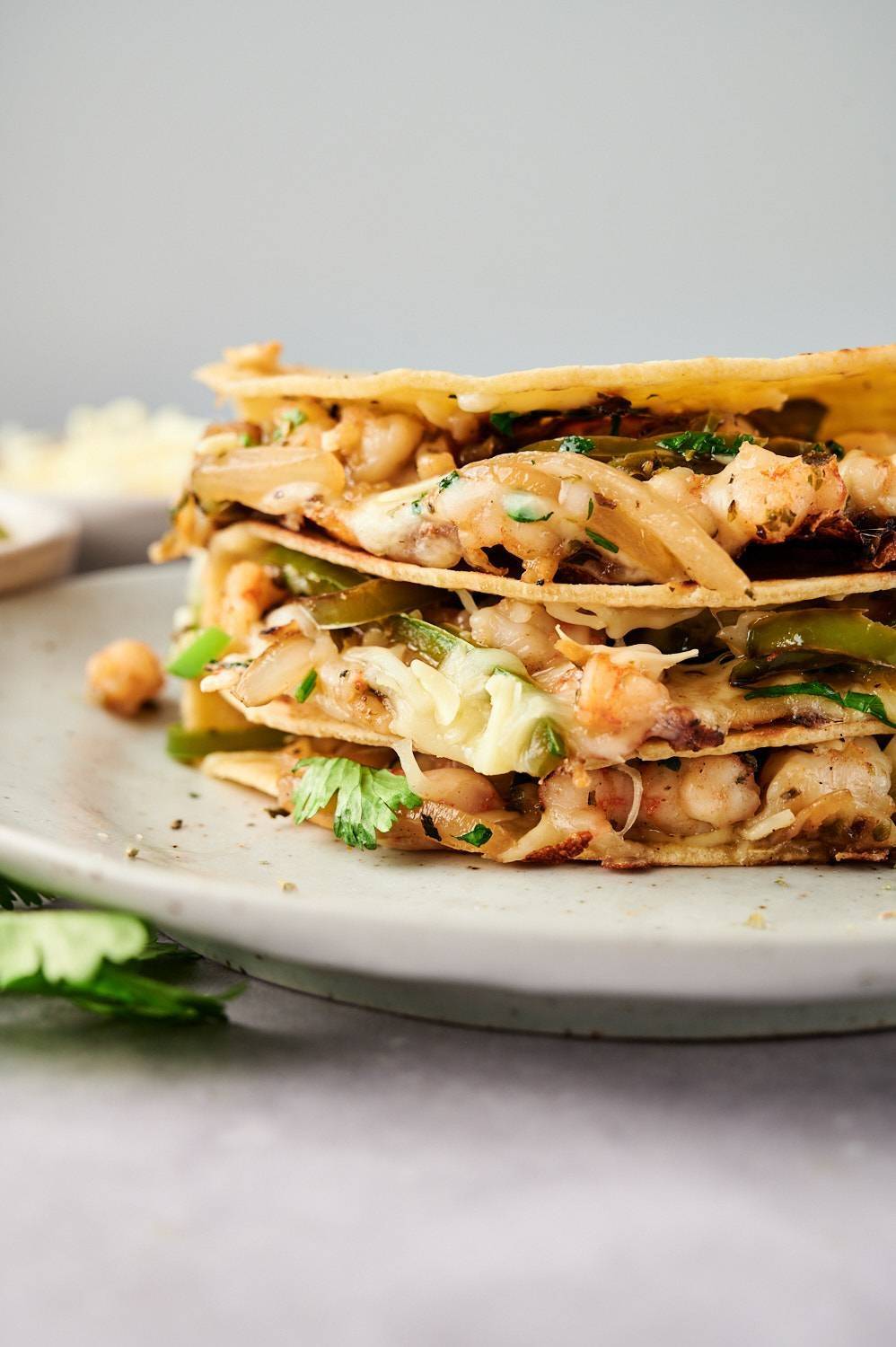 The Shrimp Taco Governor is piled on the plate and topped with melted cheese, onions, peppers and cilantro.