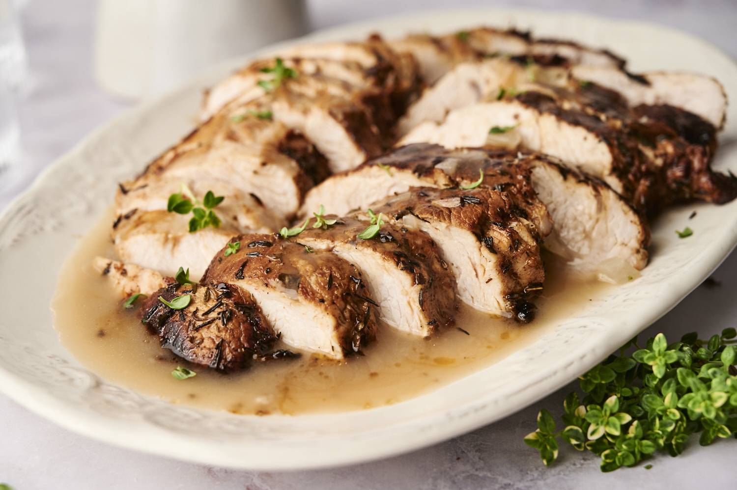 Sliced turkey tenderloin on a plate being served with homemade gravy.