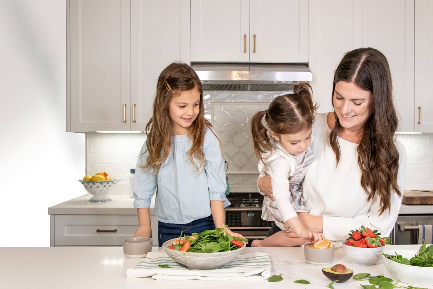 Introducing Dinner Only Meal Plans! Mom cooking with two kids in the kitchen.