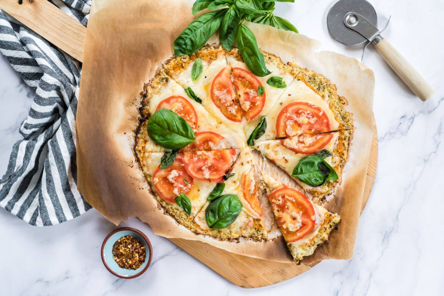 9 Cauliflower-Based Recipes Cauliflower crust pizza made with cauliflower florets and topped with mozzarella cheese, tomatoes, and basil for a low carb pizza.