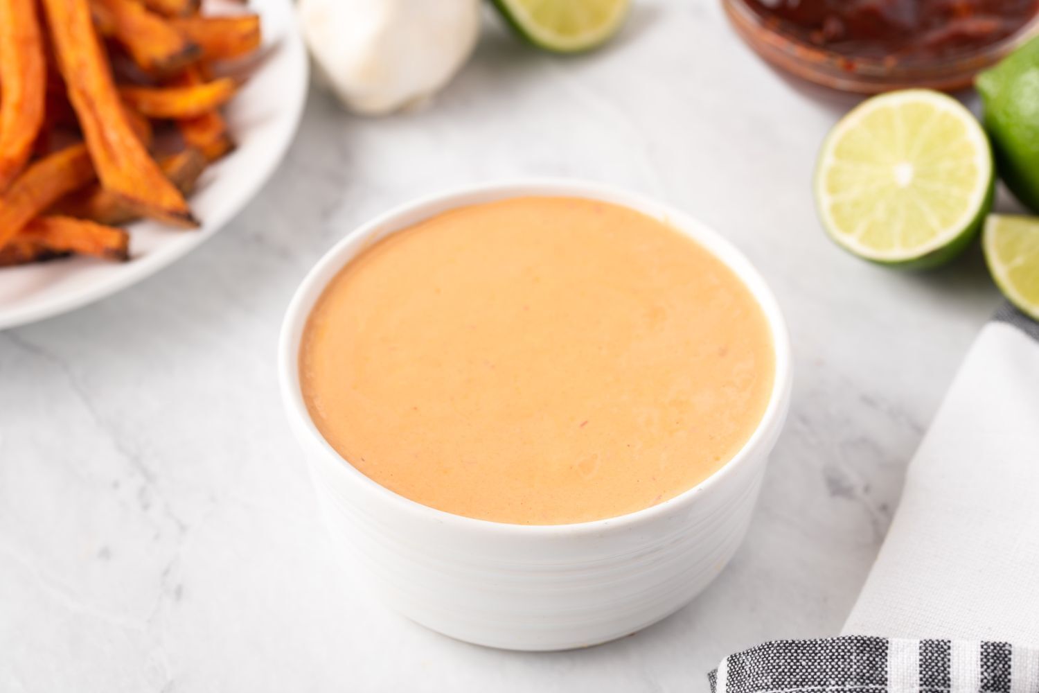 Creamy Chipotle Sauce Creamy chipotle sauce with Greek yogurt, mayonnaise, and chipotle peppers in a small white bowl with fries on the side.