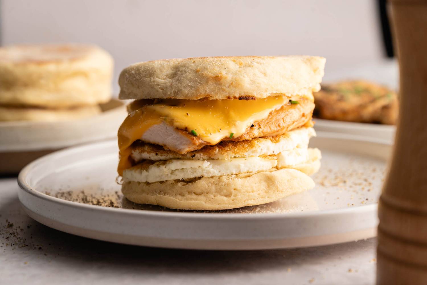 Chick-fil-A (But Better!) Egg White Breakfast Sandwich A breakfast sandwich on a plate, featuring a fluffy English muffin, melted cheese, chicken, and egg, conveying a warm, appetizing feel.