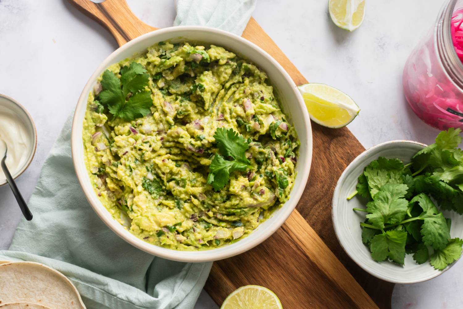 Guacamole Guacamole with mashed avocados, cilantro, red onion, jalapeno, lime juice, salt, and pepper in a bowl.
