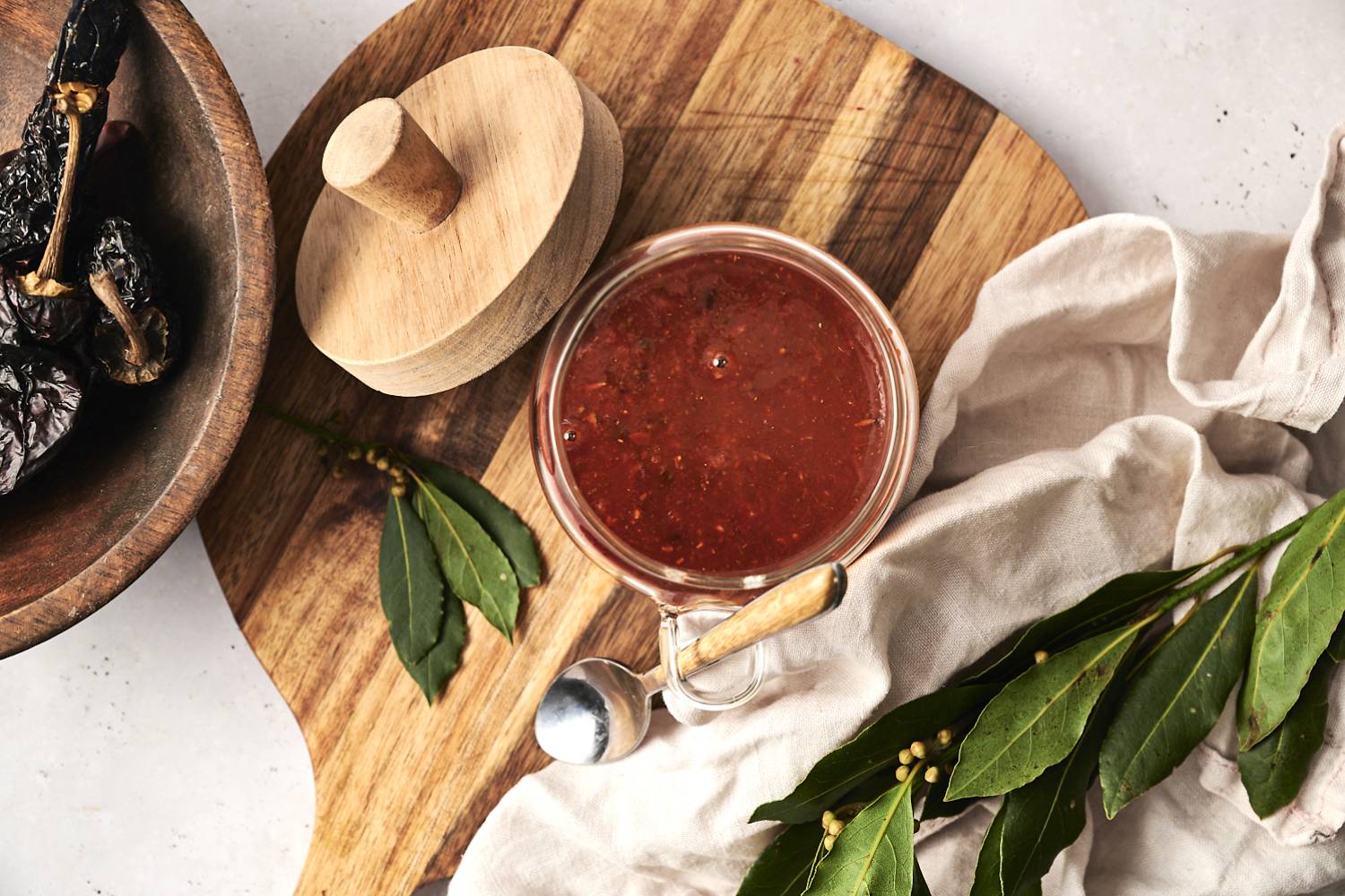 Mexican Adobo Sauce Mexican adobo sauce made with dried chilies and vinegar in a glass jar with a spoon.