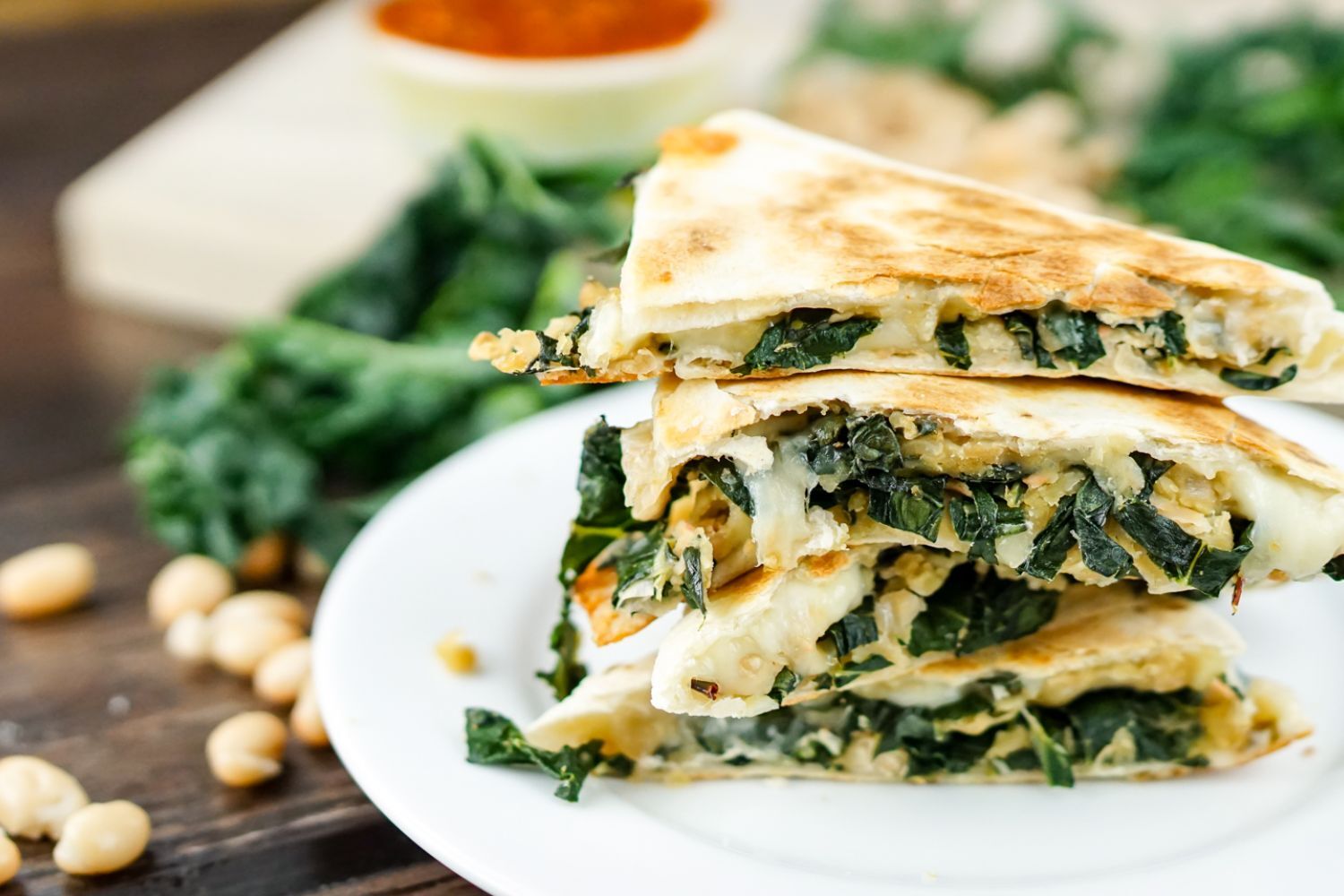 Rosemary White Bean and Kale Quesadillas White bean and kale quesadillas stacked on top of each other with salsa and cilantro.