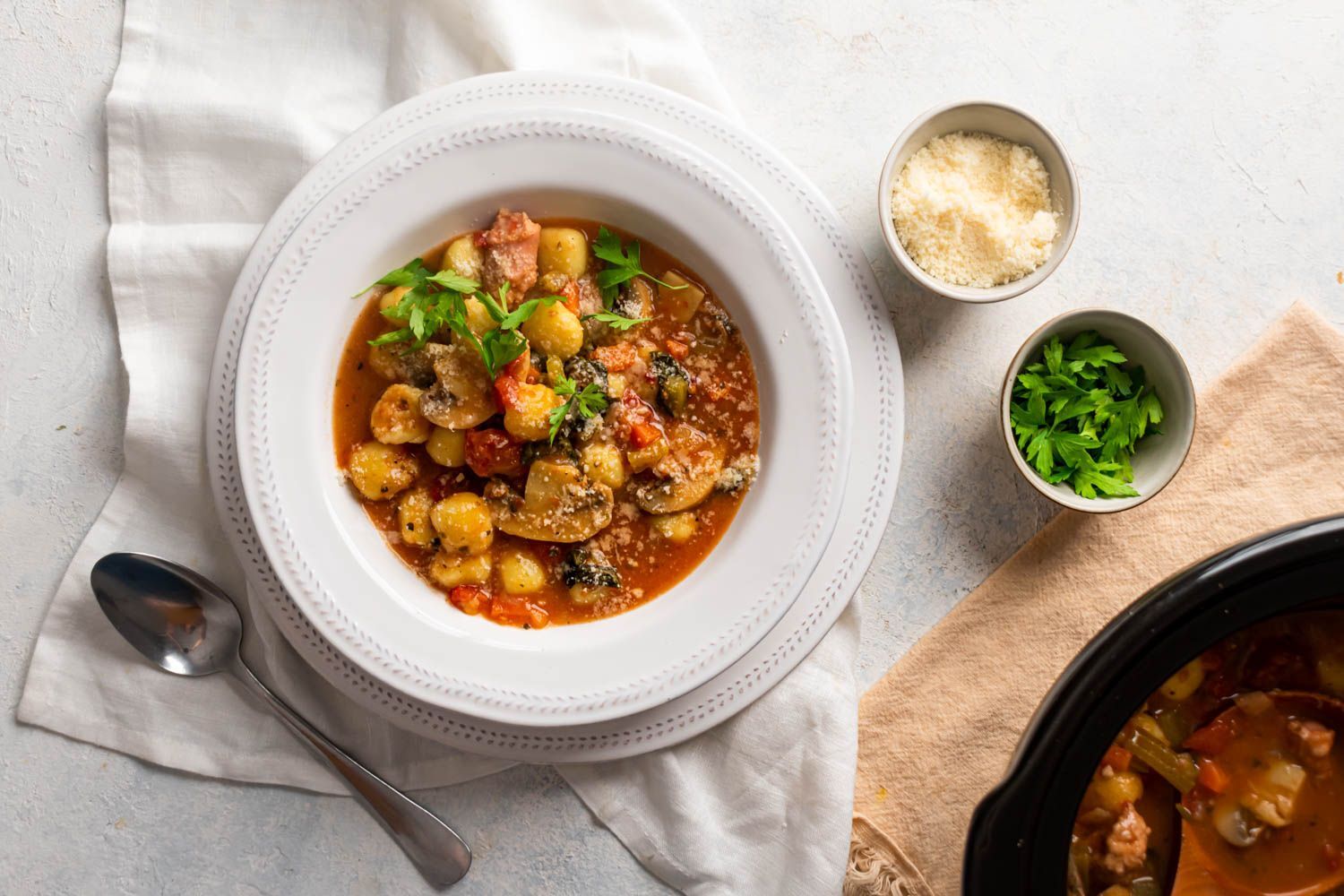 Slow Cooker Sausage Gnocchi Soup Slow cooker sausage and gnocchi soup with mushrooms, spinach, Parmesan cheese, and a rich tomato broth in a bowl.