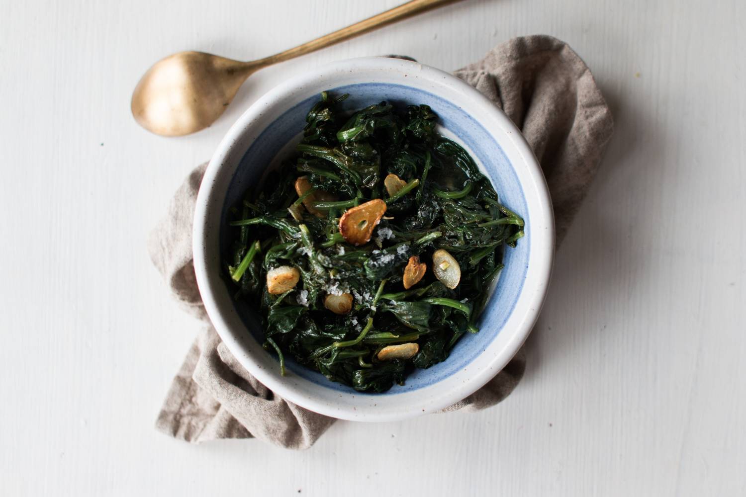 Sauteed Spinach Sauteed spinach with golden brown garlic in a skillet.