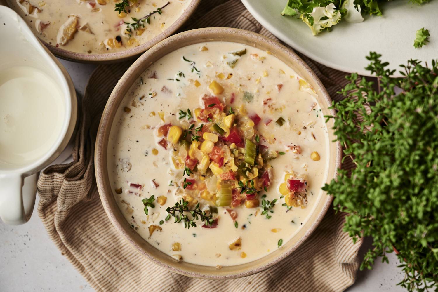 Slow Cooker Roasted Corn Chowder A bowl of creamy slow cooker roasted corn chowder topped with roasted vegetables, fresh thyme, and black pepper.