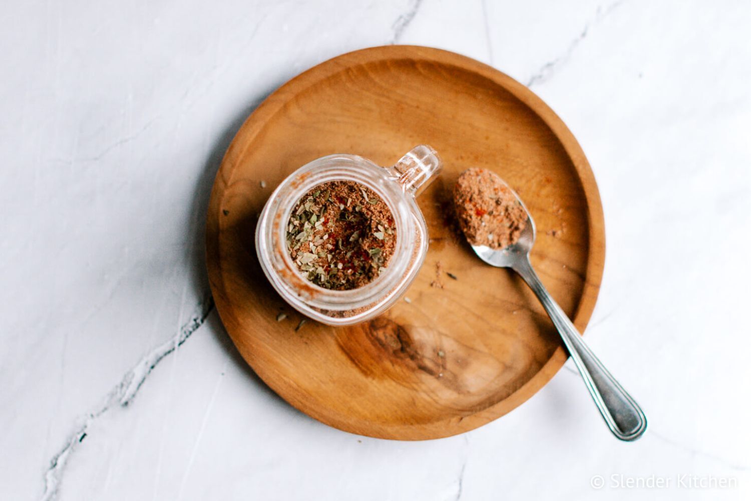 Homemade Taco Seasoning Homemade taco seasoning in a small jar with a spoon including chili powder, oregano, paprika, cumin, and other spices.