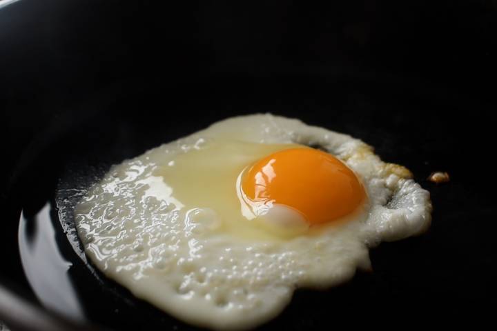Eggs are cooked in the pan on sunny day.
