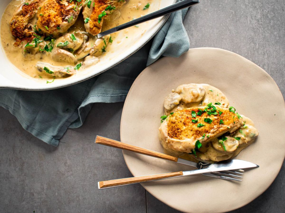 Slow cooker chicken marsala with chicken breast in a mushroom marsala sauce on a plate with parsley.